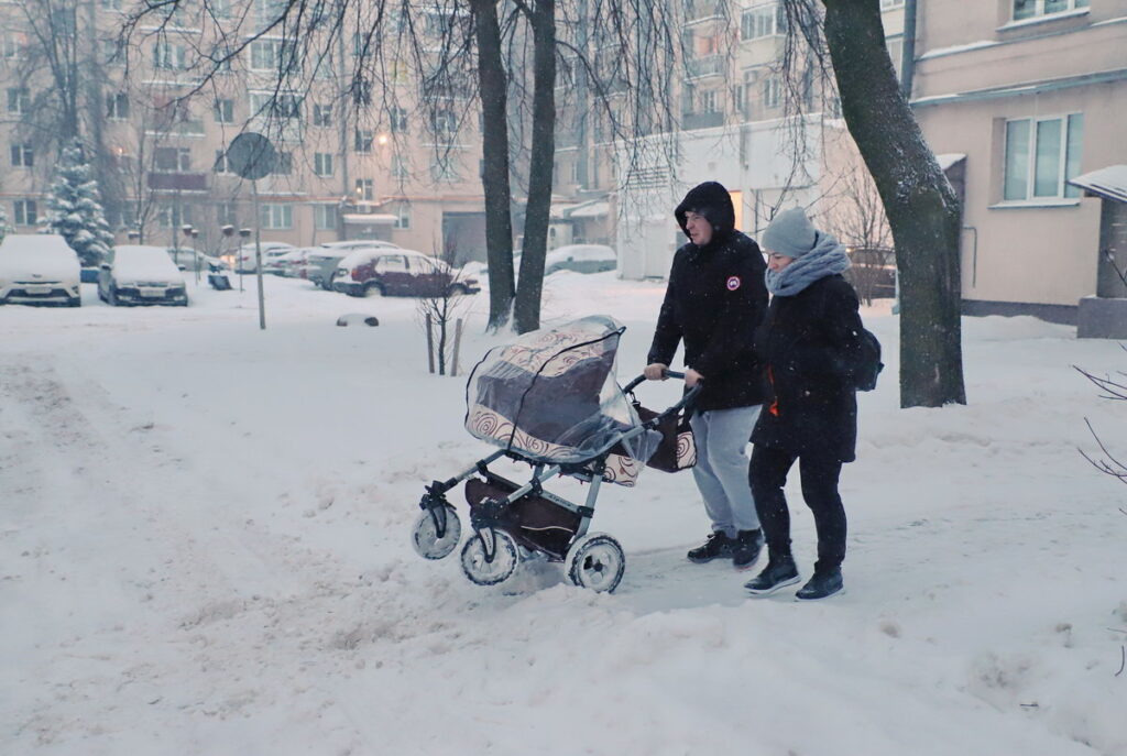 родители с коляской в снегу