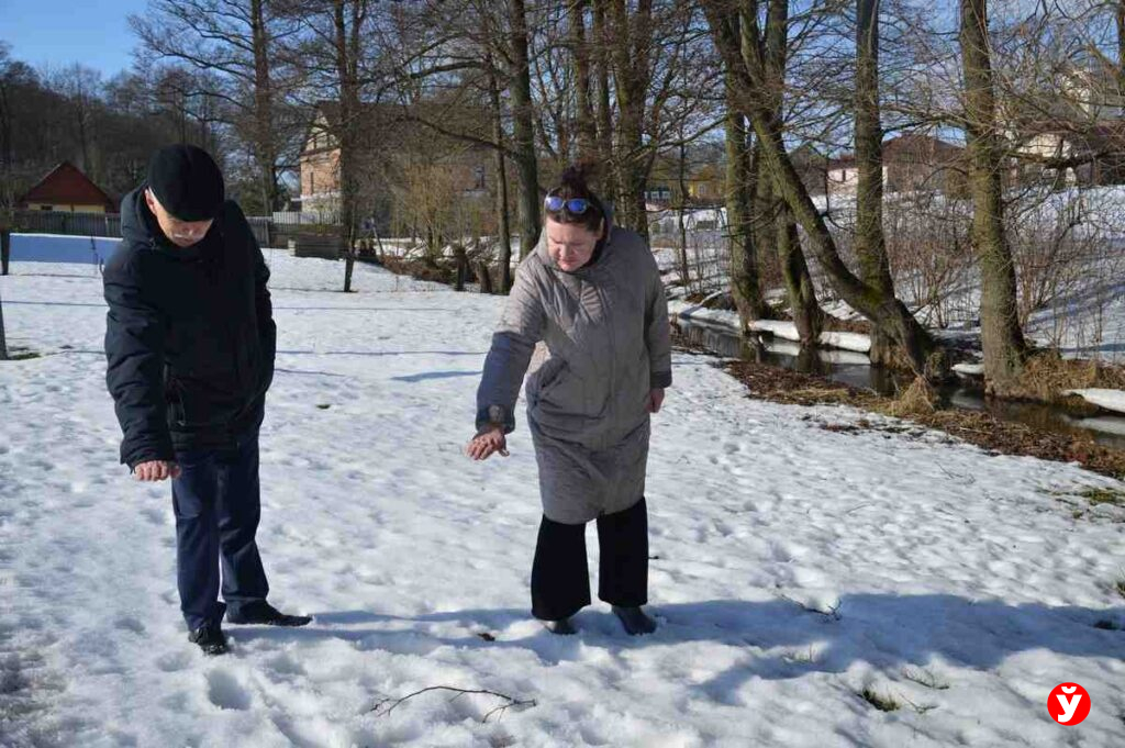 Председатель сельисполкома и местная жительница Оксана Бохан показывают на какую высоту может подниматься вода из речки Жатеревка при половодье